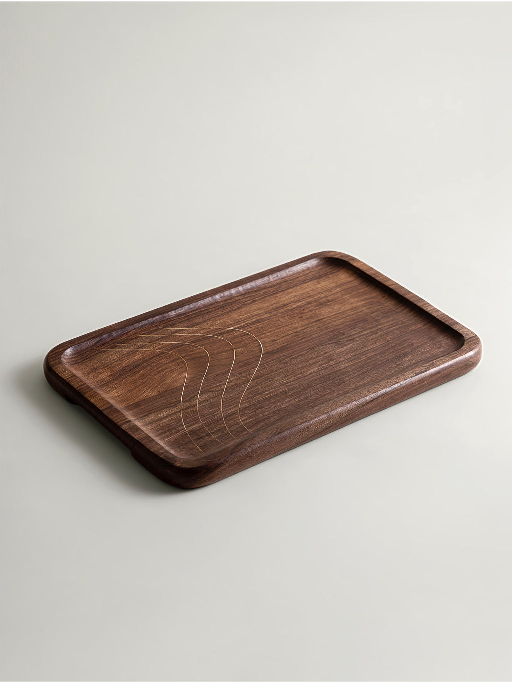 A rectangular dark brown wooden tray with rounded corners and a carved wave-like pattern in the center with brass threads, shown on a light gray background.