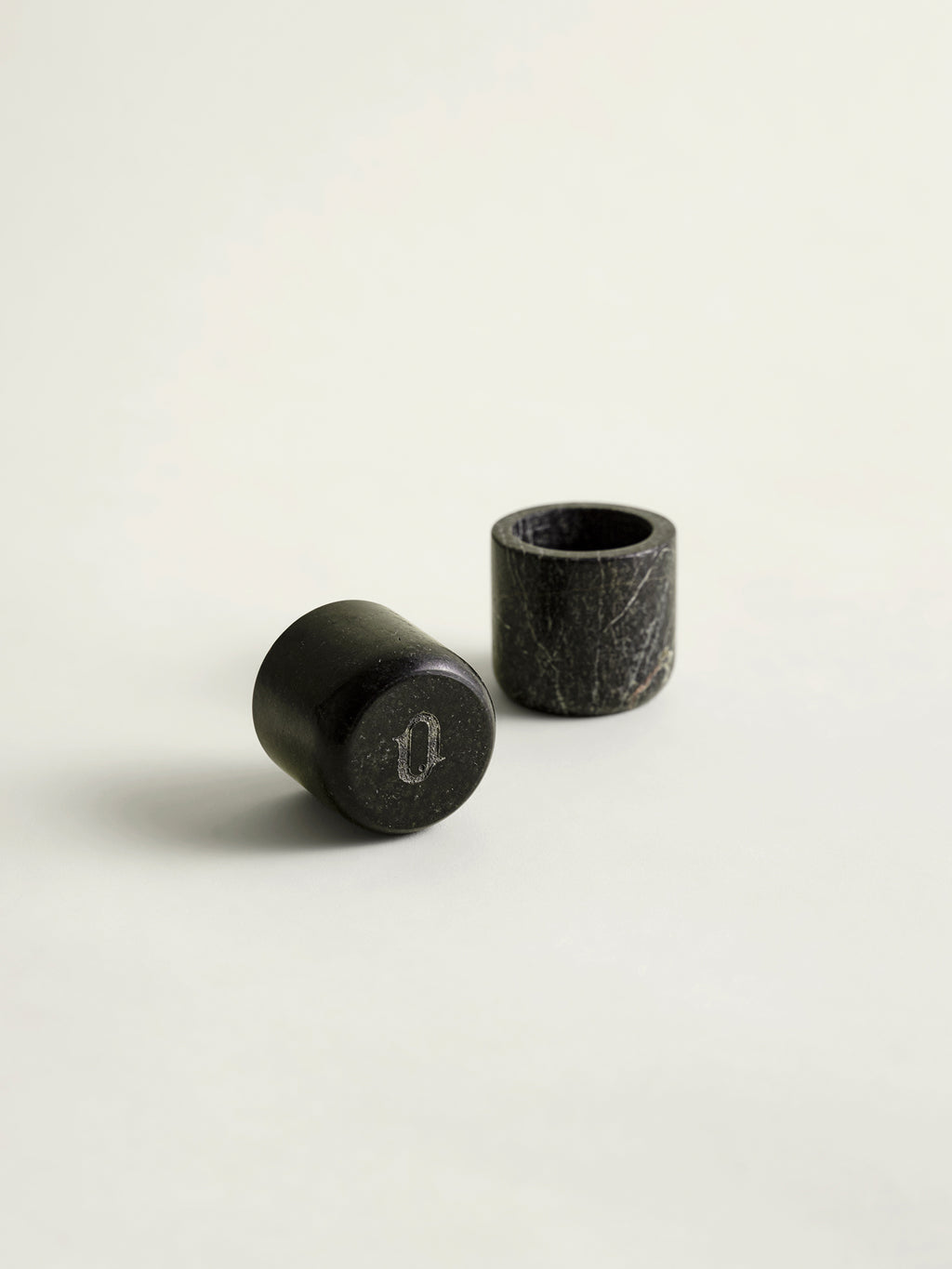 Two rainforest green marble candle holders on a white background
